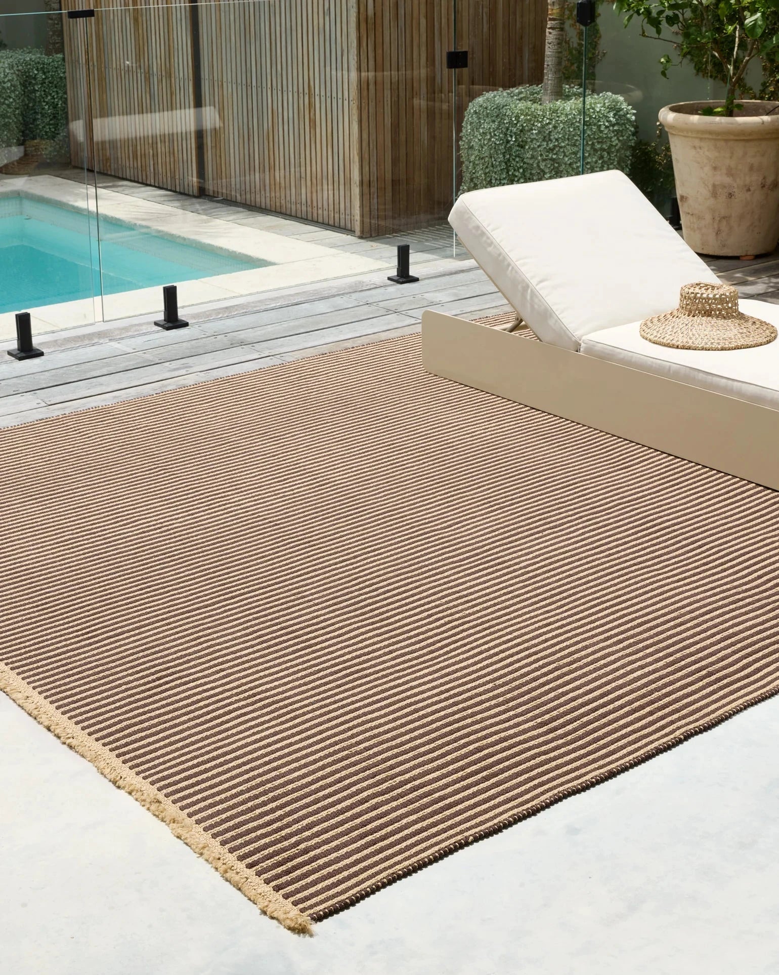 Seasons Ribbed Outdoor Rug in Brown near a pool