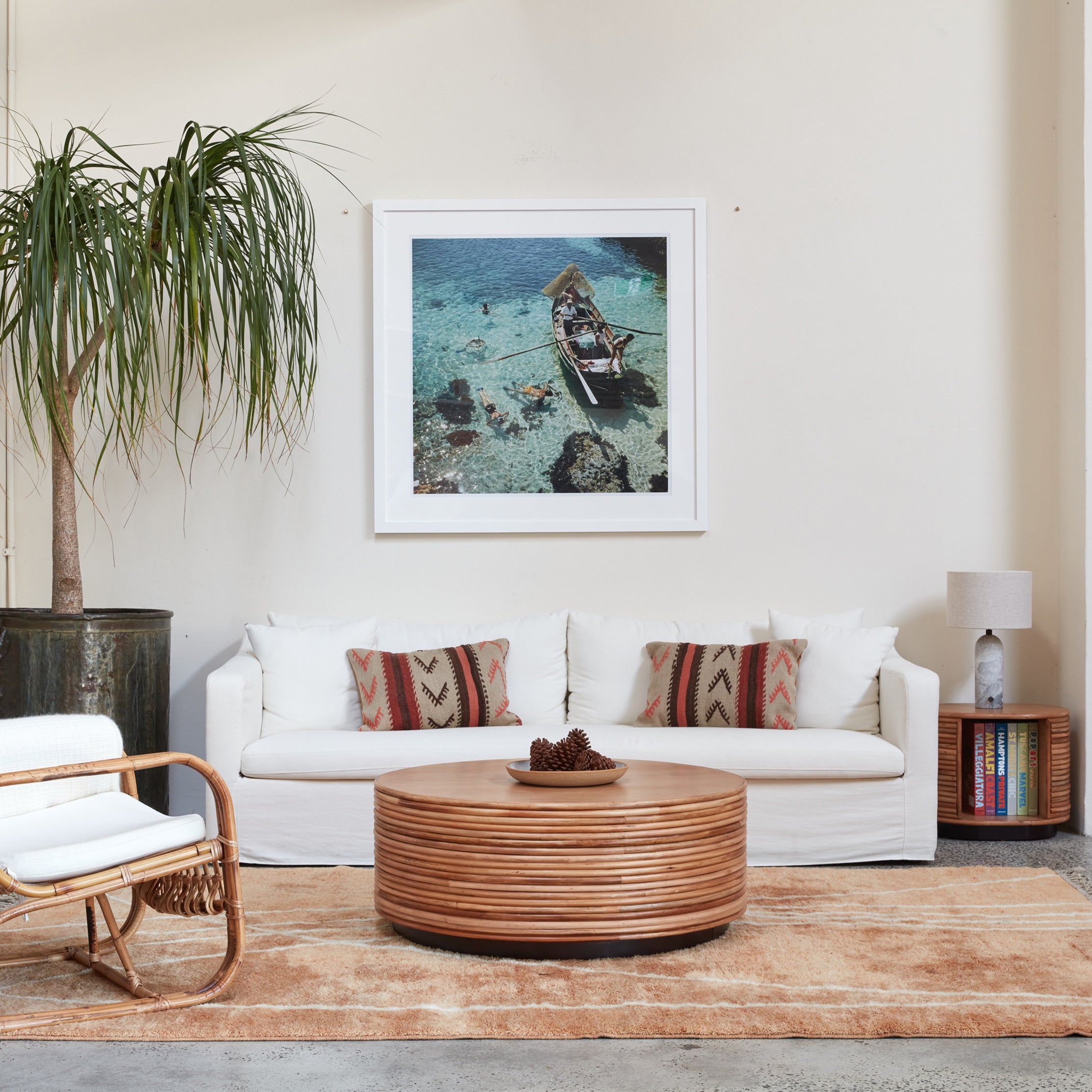 Living room with the Ayla Cream sofa, wooden coffee table, and framed picture on the wall.