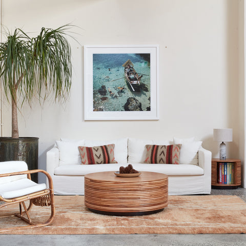 Living room with the Ayla Cream sofa, wooden coffee table, and framed picture on the wall.