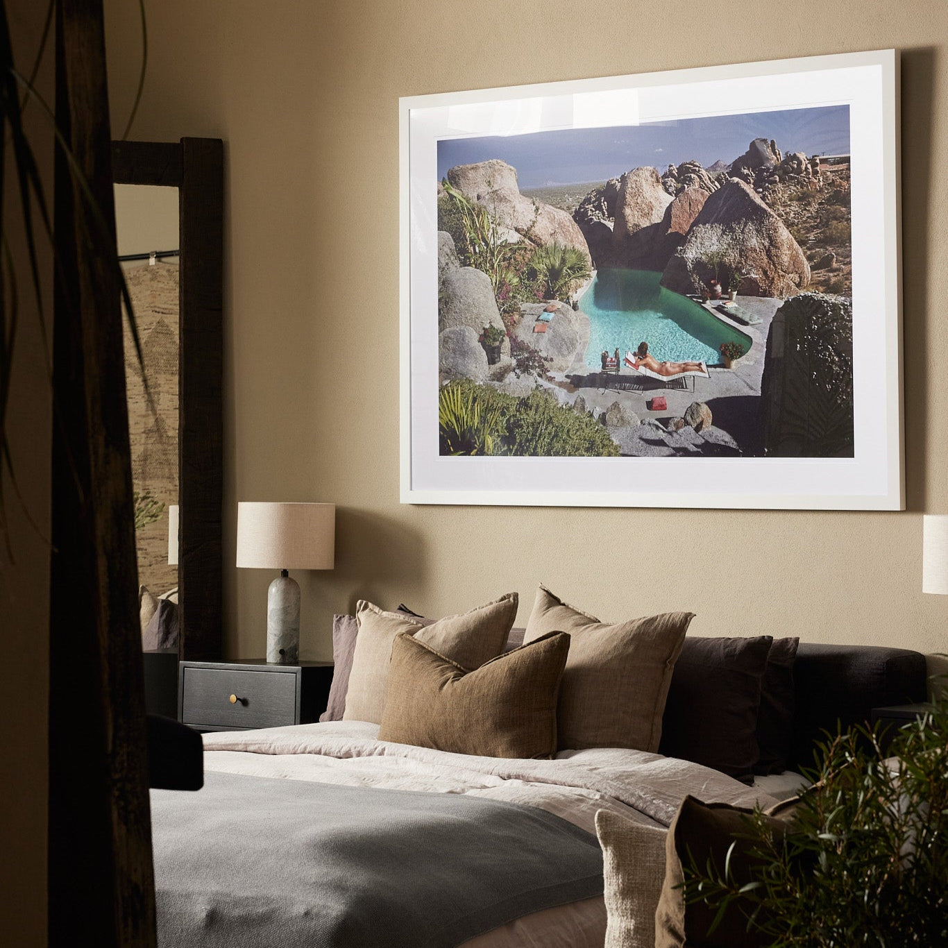 Bodhi Living bedroom with a large Slim Aarons's framed photo behind bed 'Sunbathing in Arizona'.