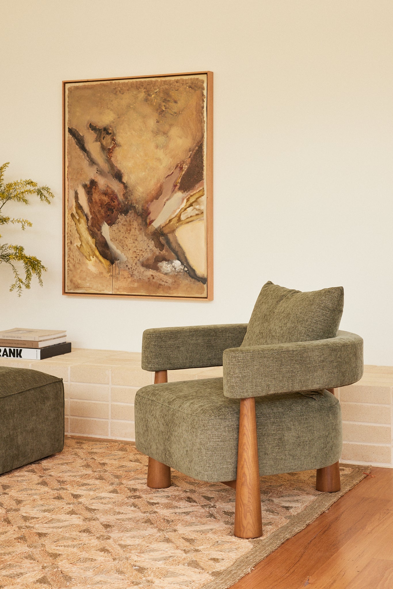 Arlo Armchair in Forest fabric styled in a contemporary living room with original artwork by Stephen Skinner.