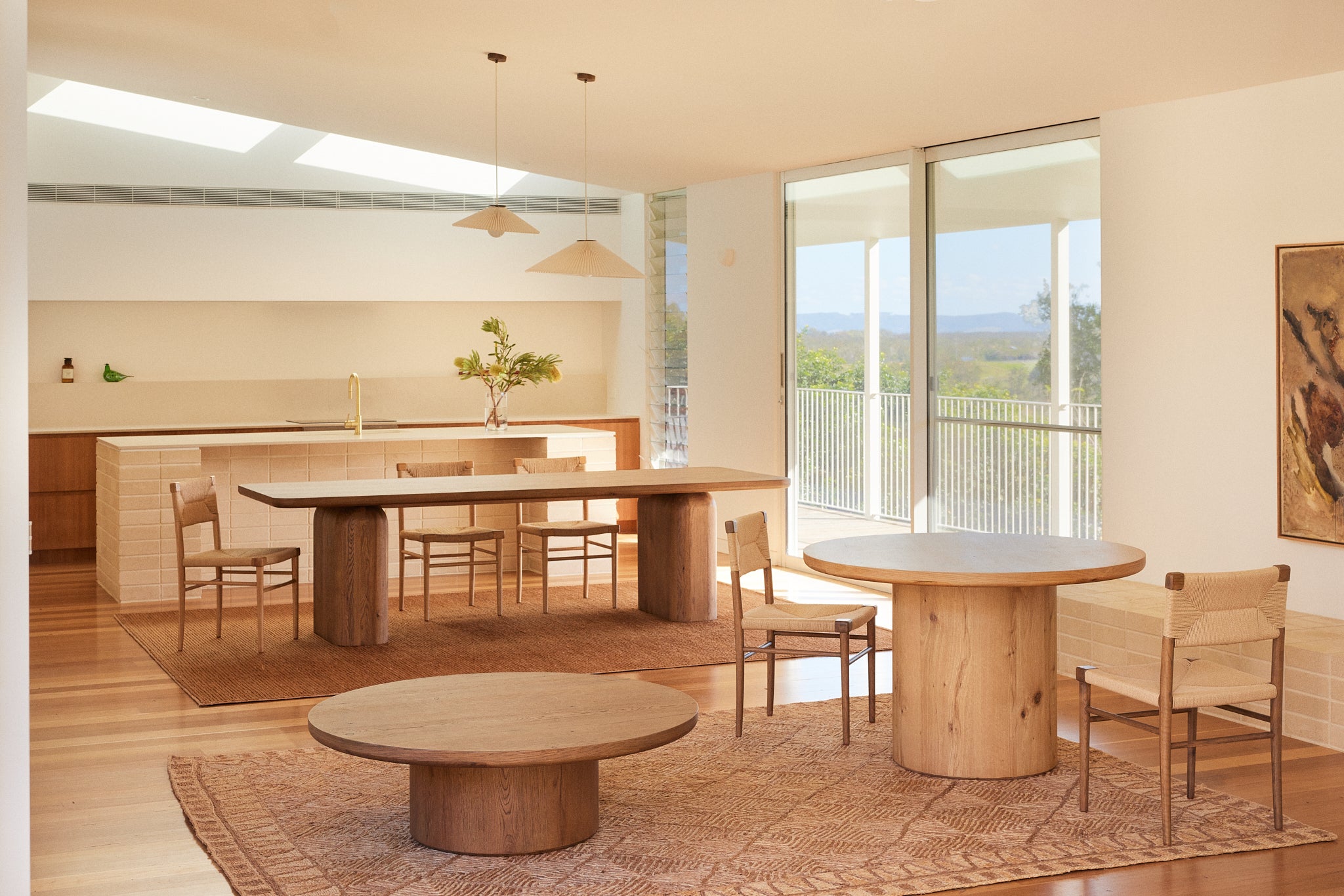 Alta round coffee table and dining table in Oak and Archer dining table in Oak in a contemporary open-plan interior.