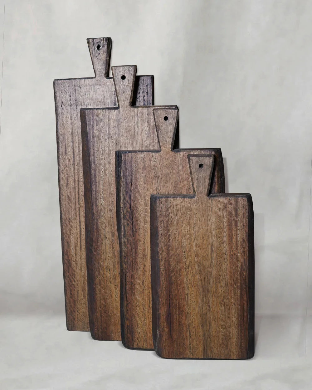 Four natural recycled hardwood chopping boards in varying sizes, showing live-edge grain and smooth oiled surfaces 
