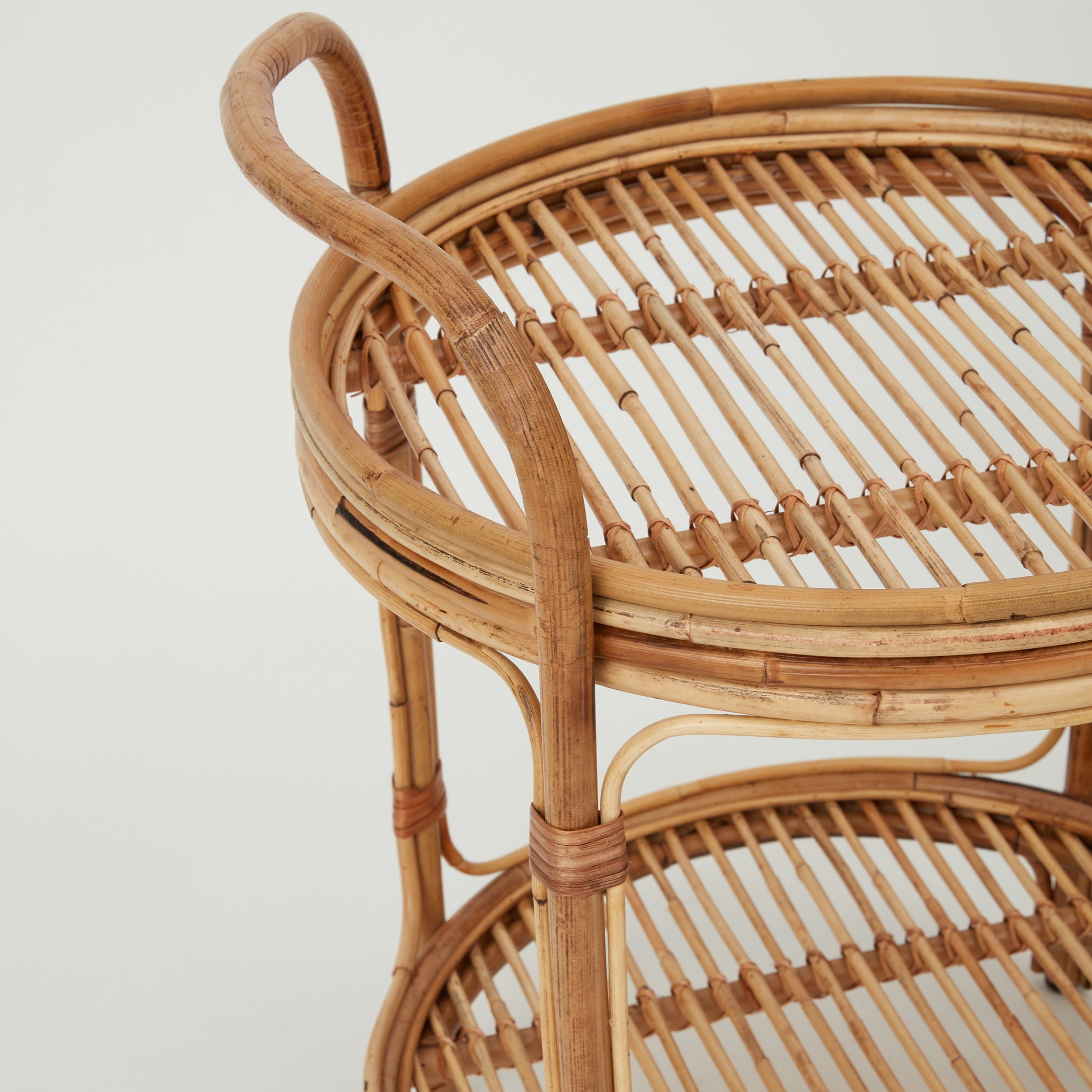 Capri rattan bar trolley with curved handles and woven cane detail, side angle.