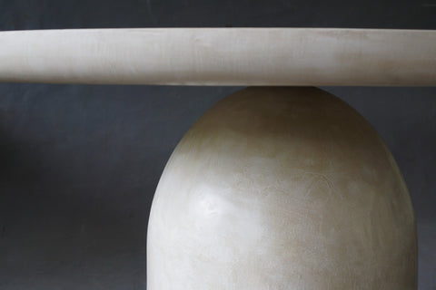 Closed-up of the Nexus Round Dining Table in Oyster highlighting smooth micro cement finish.