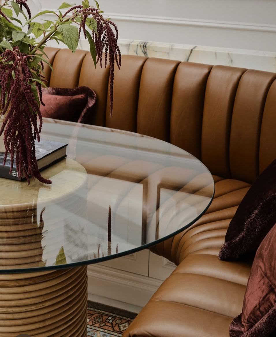 Brown leather sofa with Laguna glass dining table in a living room setting