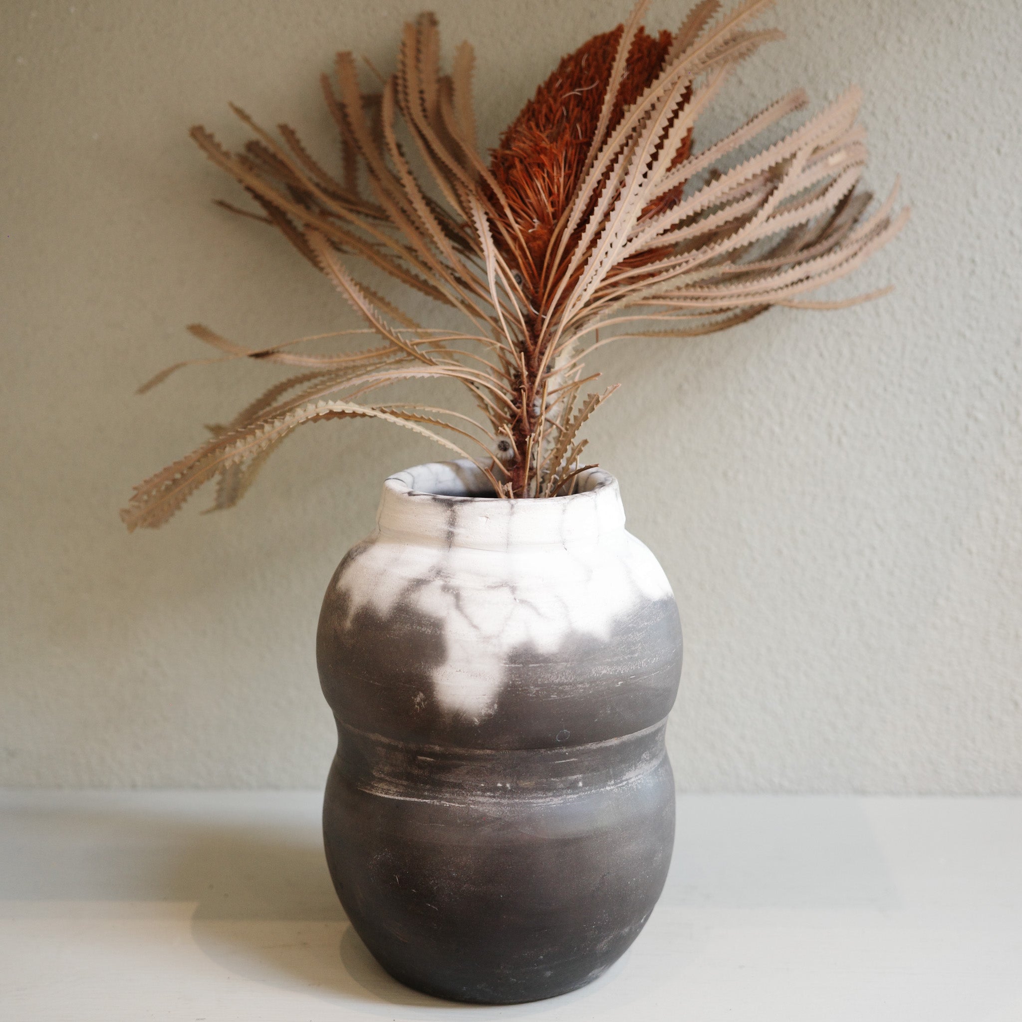 Naked raku ceramic vase with smoky monochrome finish, handmade by Australian artist Jacqui Sosnowski.
