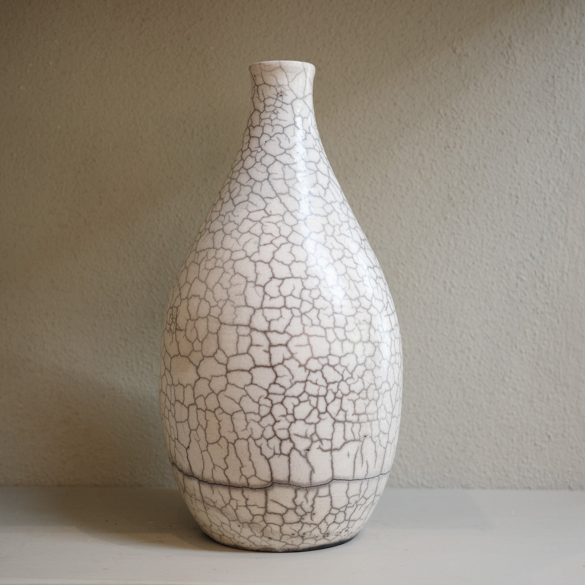 Handmade ceramic raku vase with crackle glaze finish in white and smoky grey by Australian artist Jacqui Sosnowski.