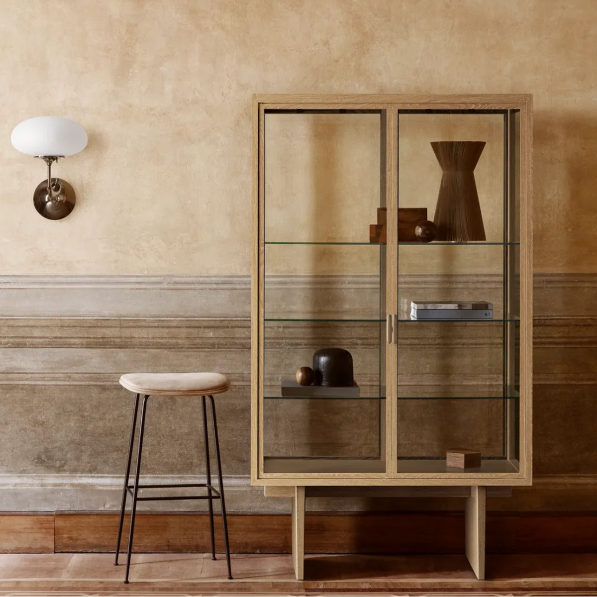 GUBI Private Vitrine in light stained oak styled in a warm-toned room with minimalist decor
