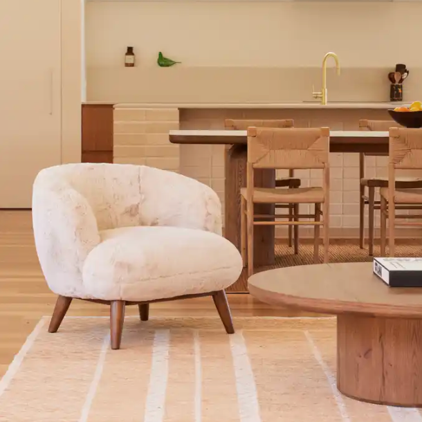 Rumi faux fur armchair styled with the Alta round coffee table in aged brown oak in a contemporary living room.