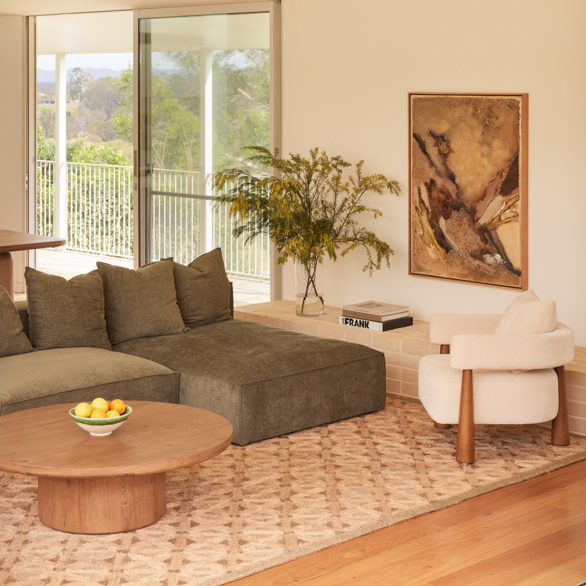 Cosmos 3 Piece Modular Sofa with chaise in Forest green fabric styled with the Arlo armchair in Oatmeal