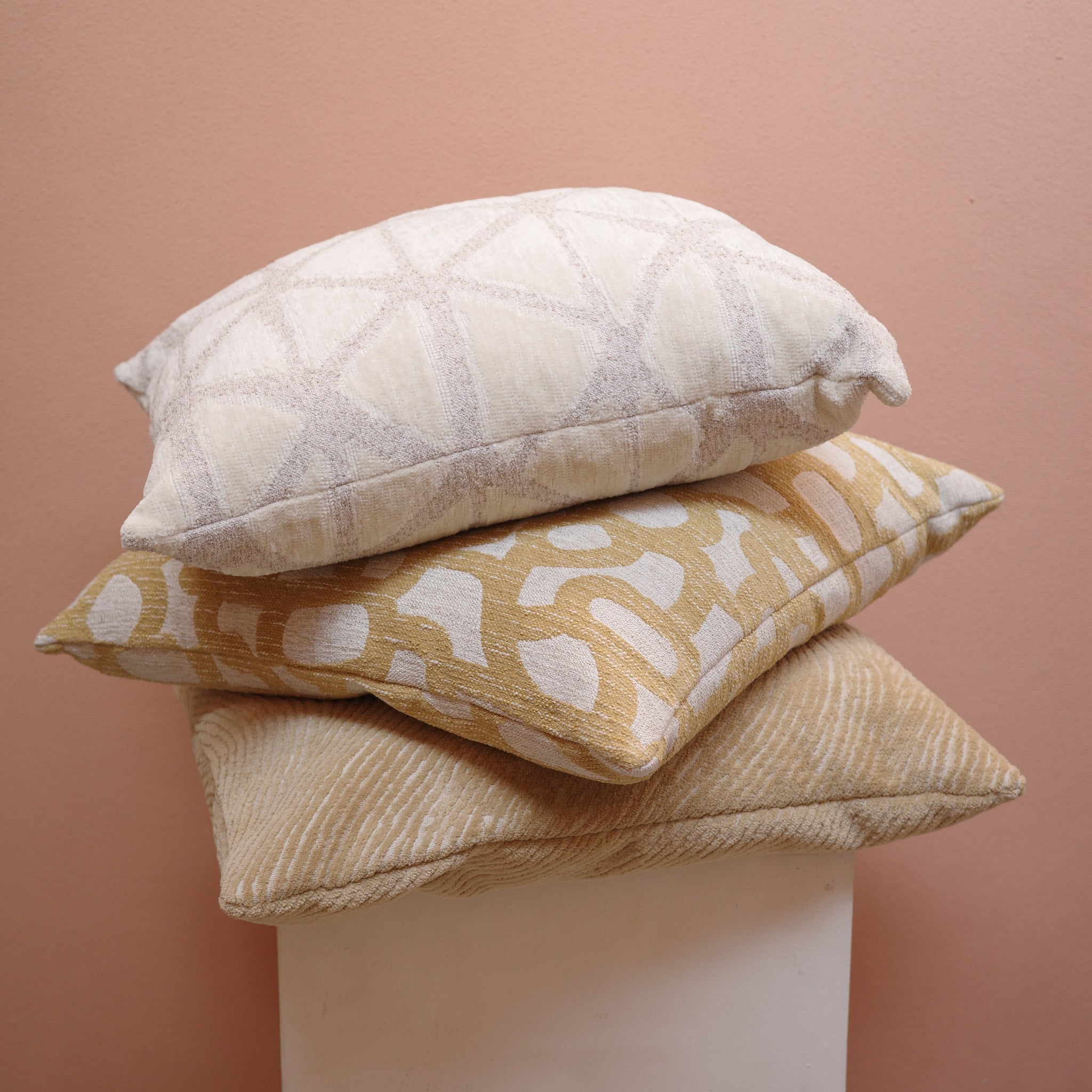 Stack of gold and neutral textured cushions – Bodhi Living
