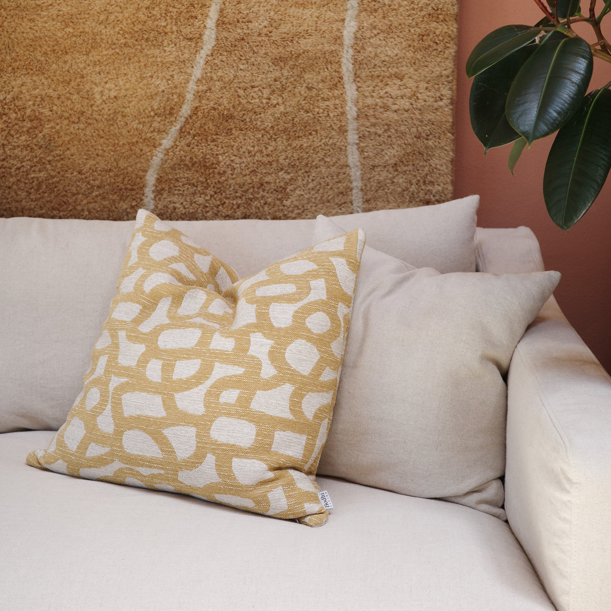 Tracks Gold Cushion 55×55 cm in gold pattern styled on sofa from Bodhi Living