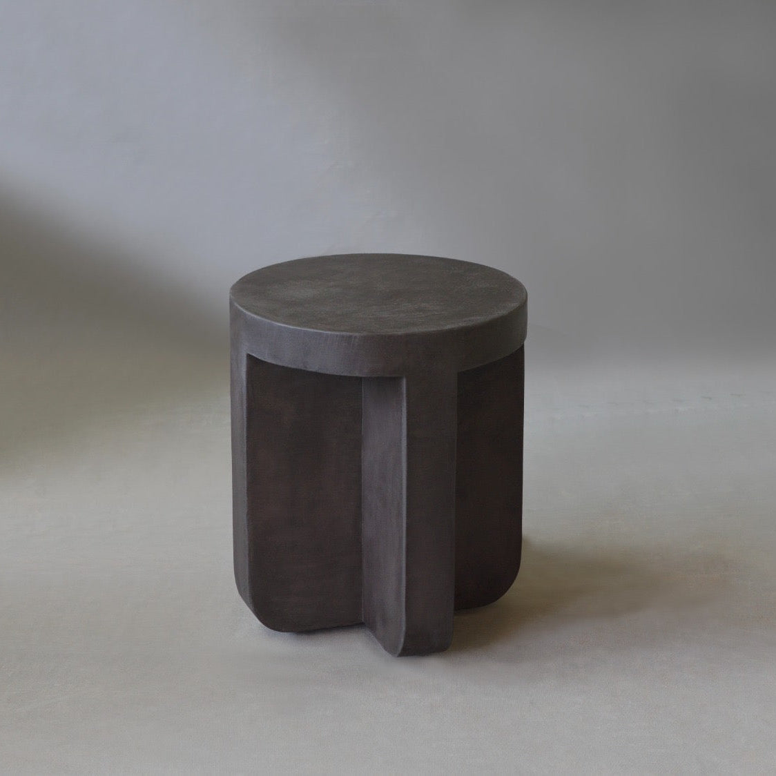 Axel Side Table in Pebble micro cement finish, highlighting its round shape and smooth texture.