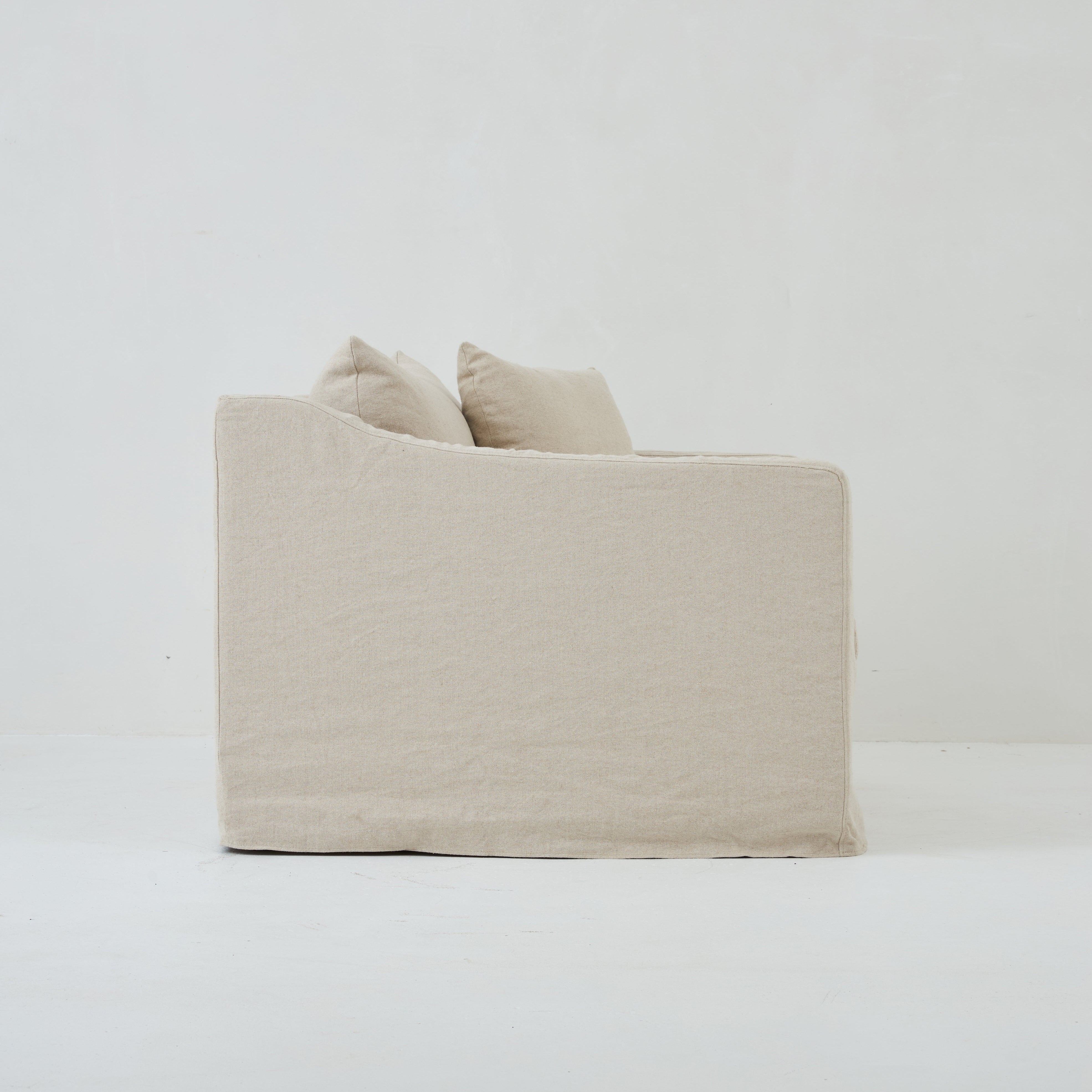 Side view of the Ayla Armchair in Beige Linen fabric loose linen cover