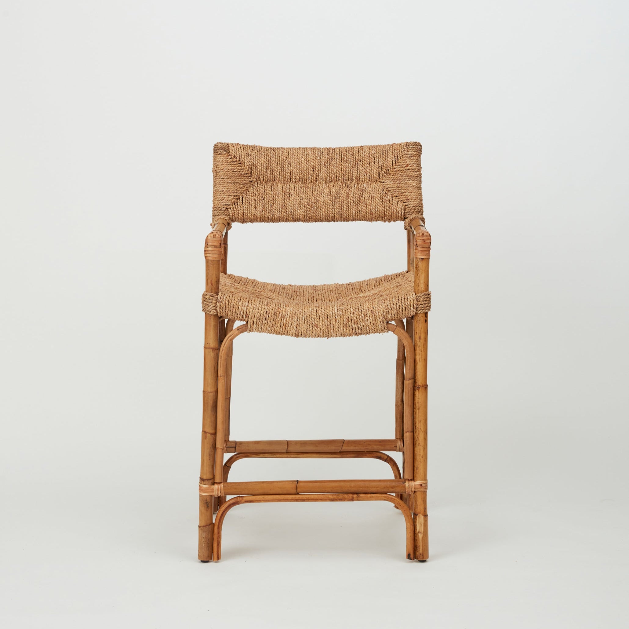 Azul Bar Stool with handwoven rope seat and backrest on natural rattan frame, front view.