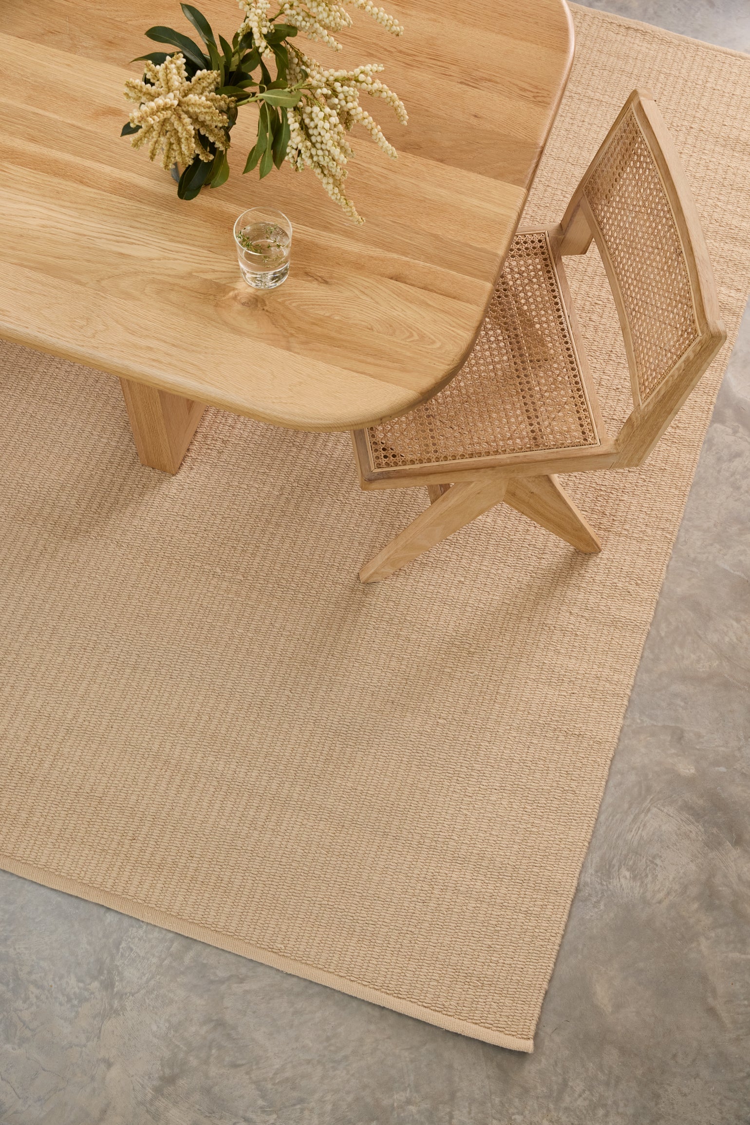 Pebble Flatweave Rug in Beige under a dining table