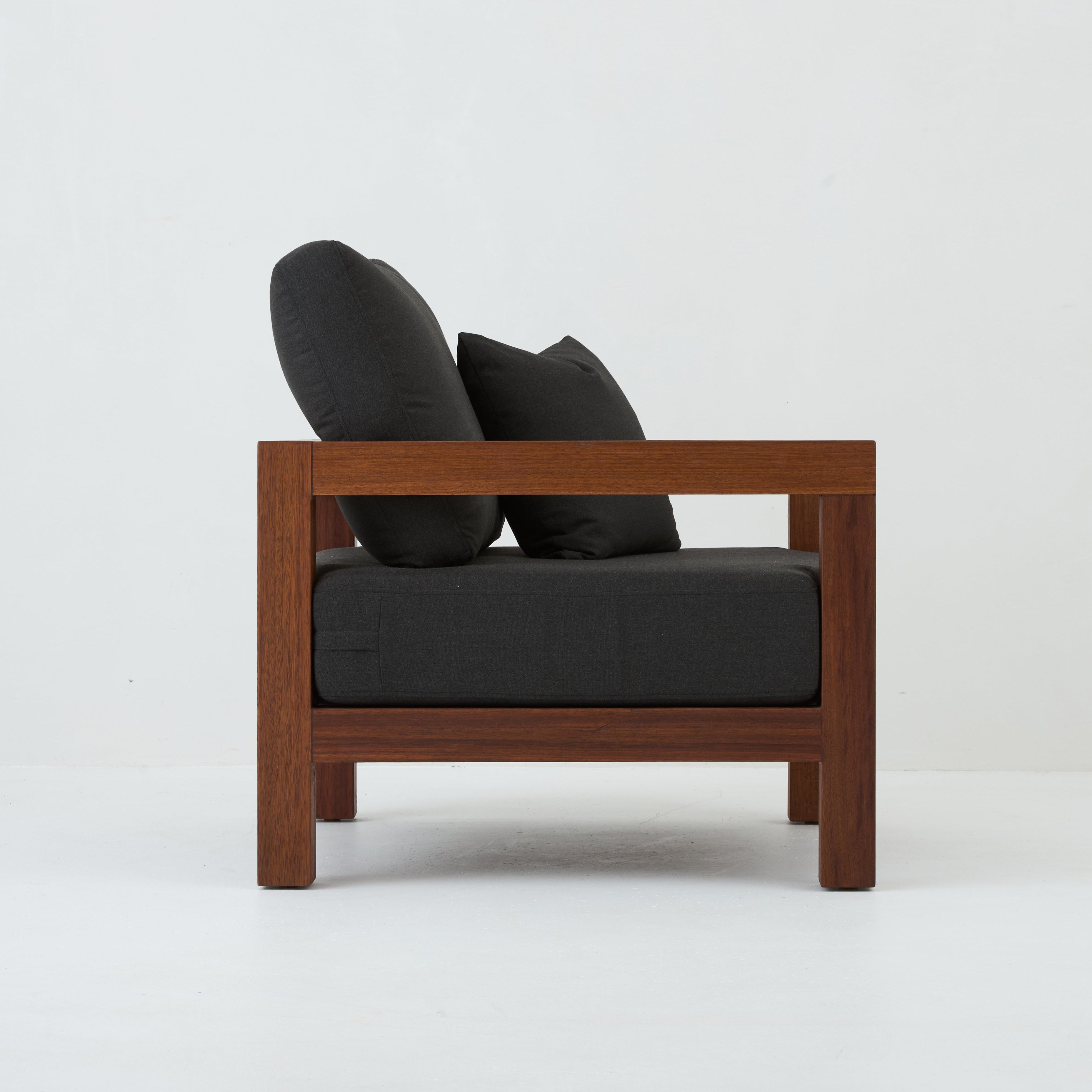 Side view of Cali teak armchair with coal cushions