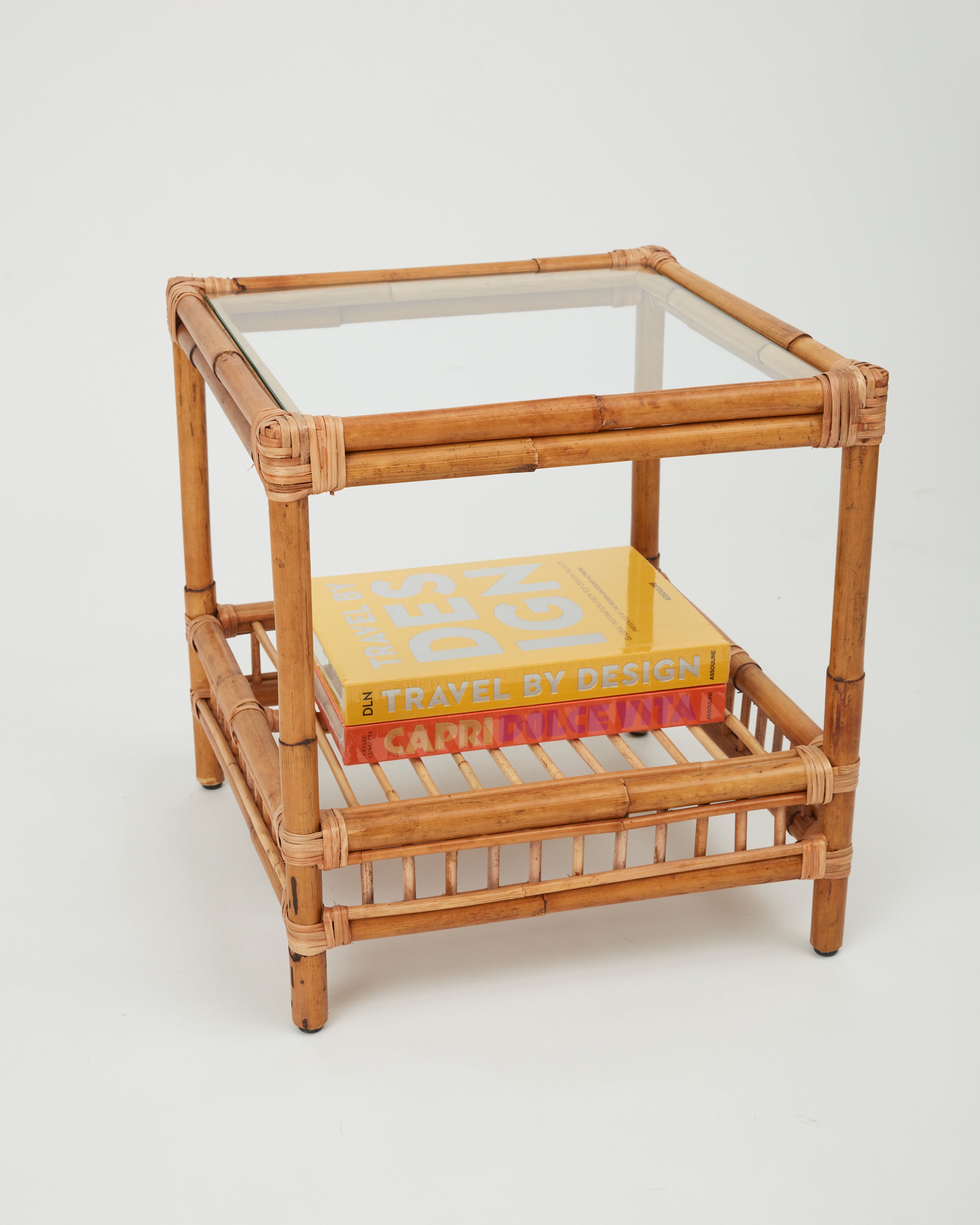 Side view of the Capri rattan side table with glass top styled with books