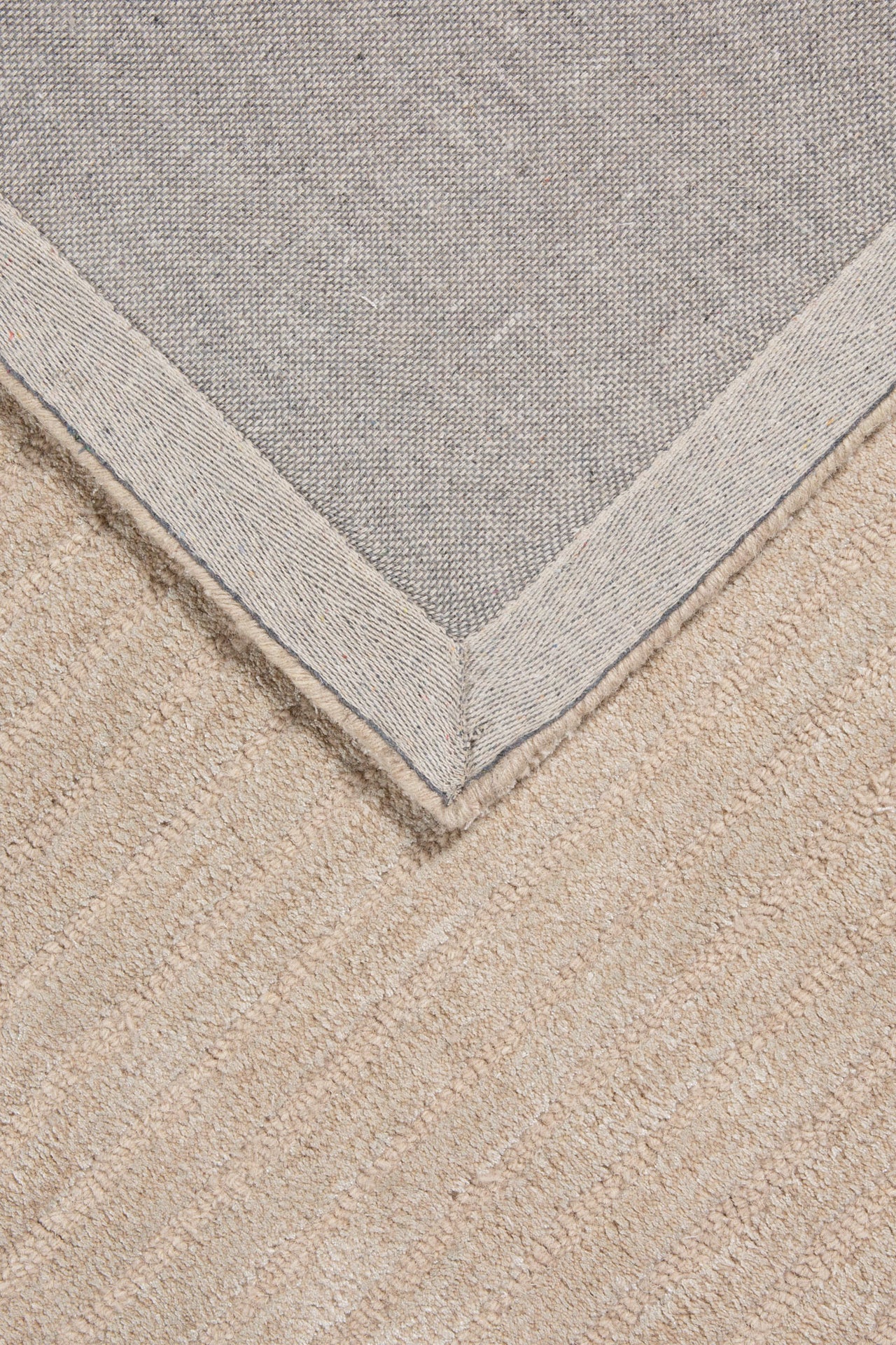 Close-up of Deco Design Taupe Rug showing raised linear and curved wool texture