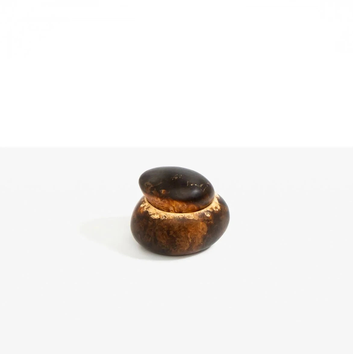 “Dinosaur Designs Small Pebble Jar in Dark Horn resin with smooth stacked pebble form.”