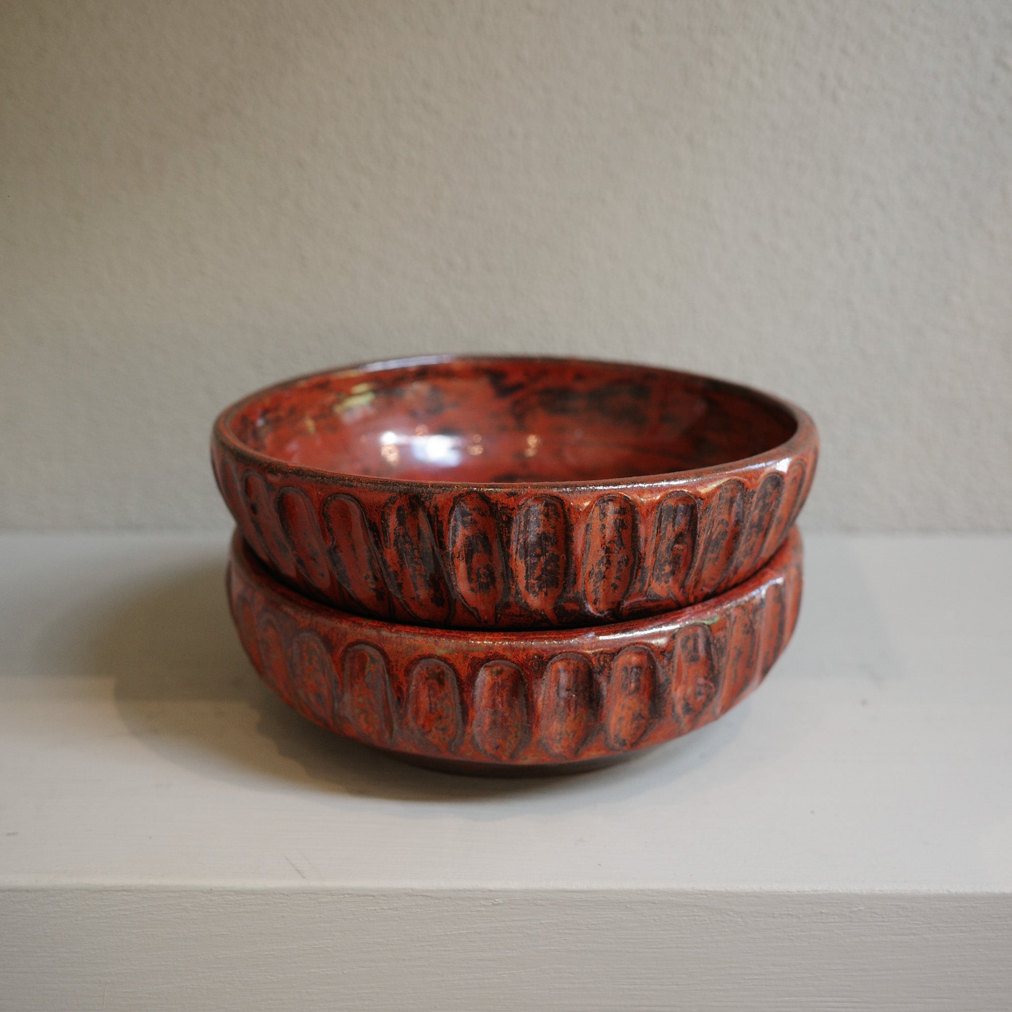 Stacked view of copper float fluted ceramic bowls showing glaze texture and handmade details.