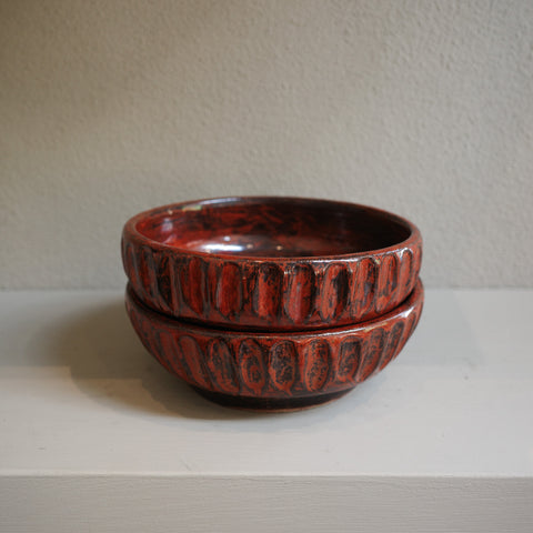 Stacked view of copper float fluted ceramic bowls showing glaze texture and handmade details