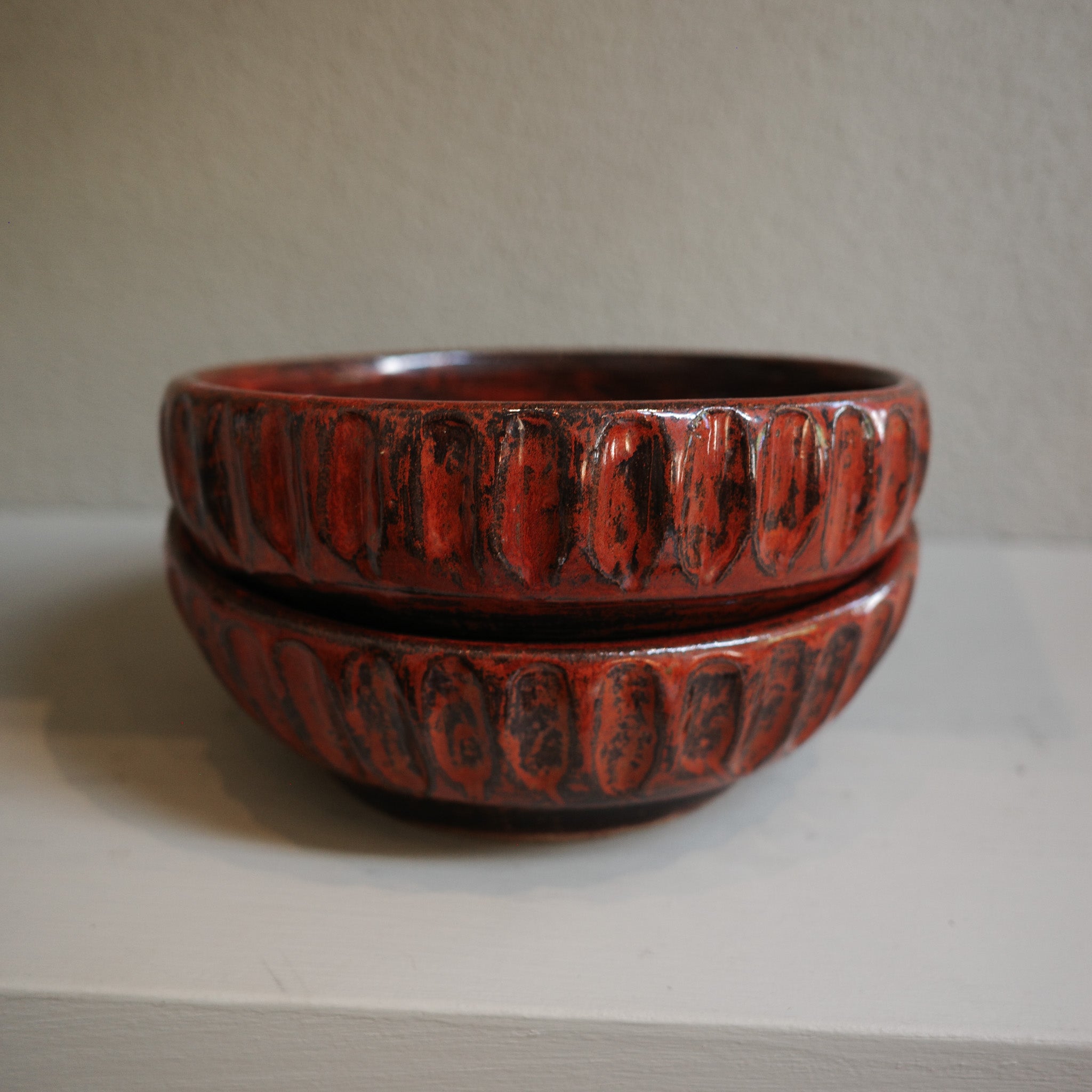Stacked view of copper float fluted ceramic bowls showing glaze texture and handmade details