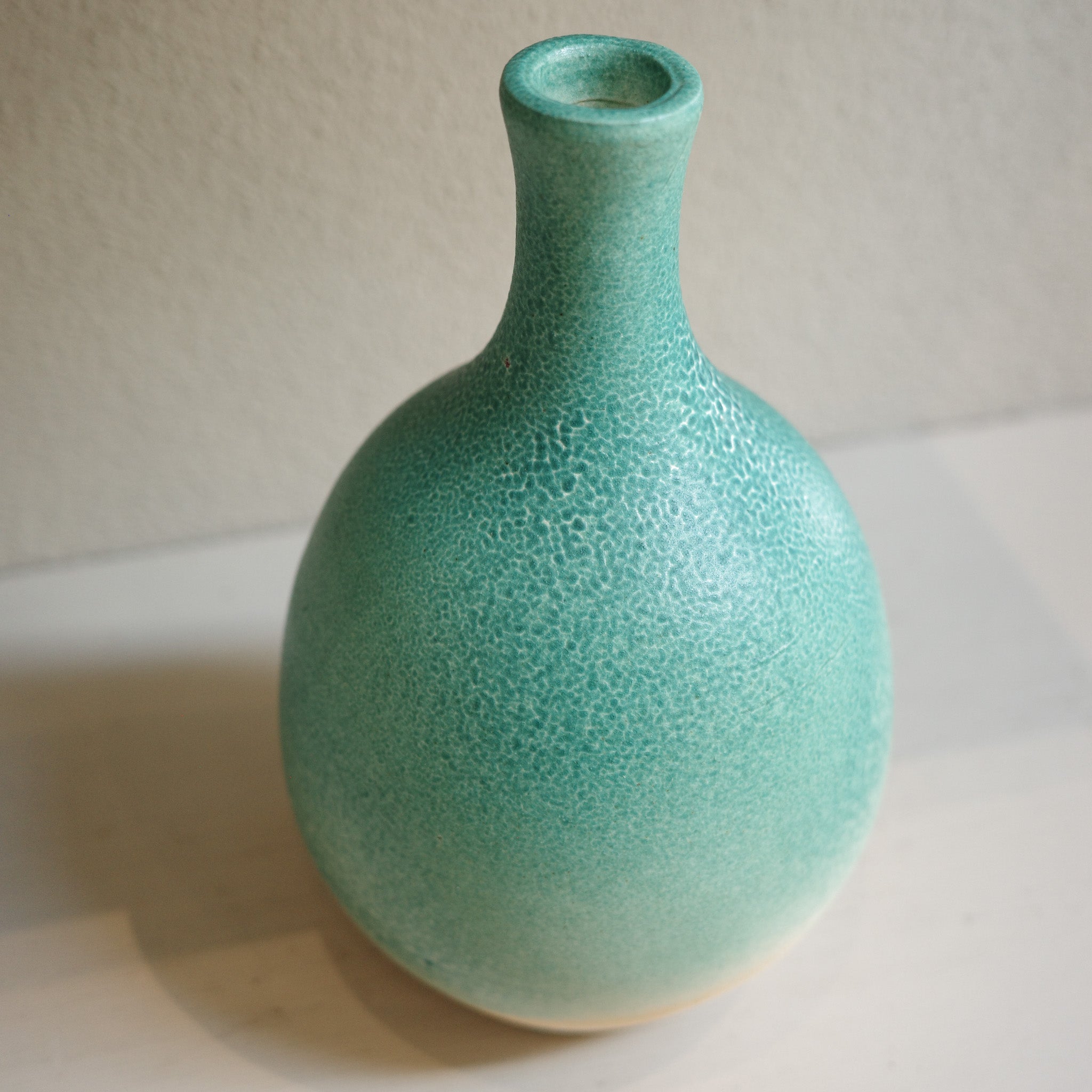 Handmade ceramic bottle-neck vase with green ombré glaze, created by Australian artist Jacqui Sosnowski, top view.