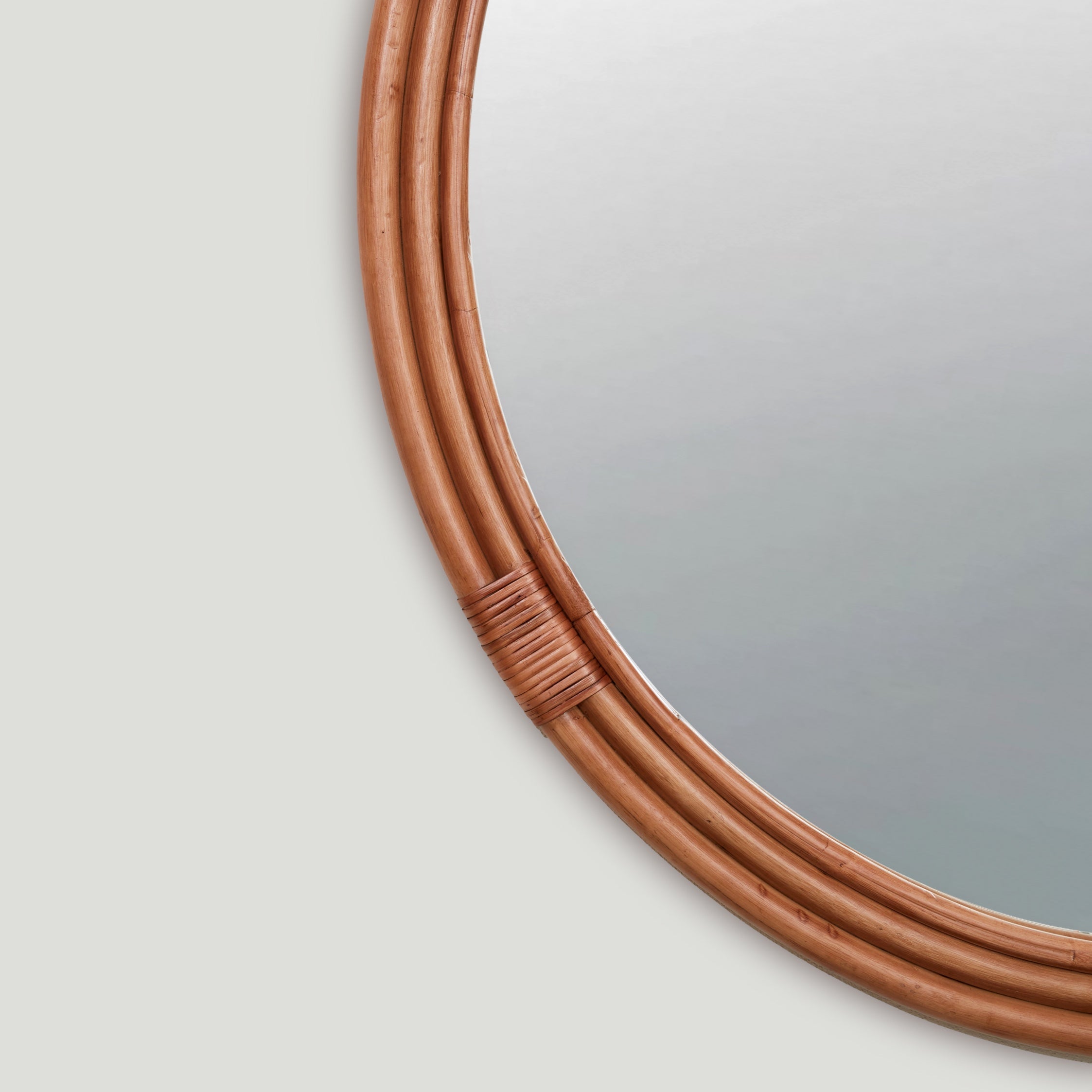 Detail of the Lani round wall mirror with rattan frame