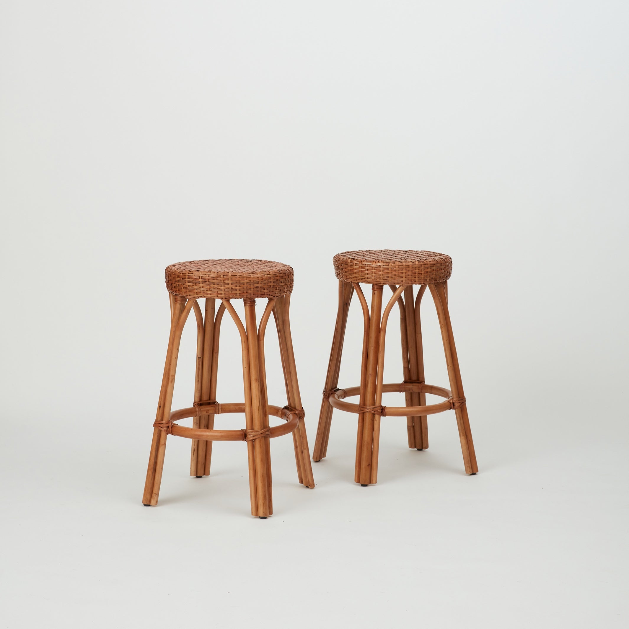 Two Leila Rattan Bar Stools in natural finish, with handwoven seats 
