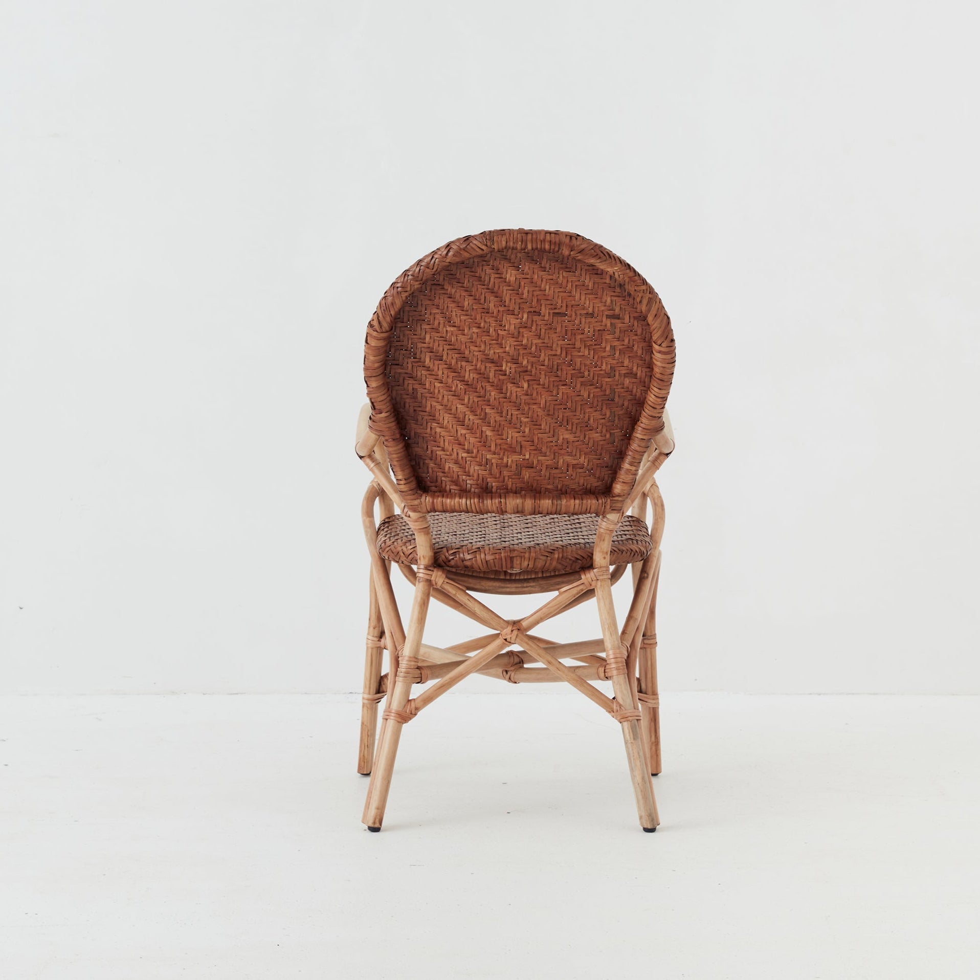 Leila dining chair with handwoven rattan seat and backrest on a natural rattan frame, back view.