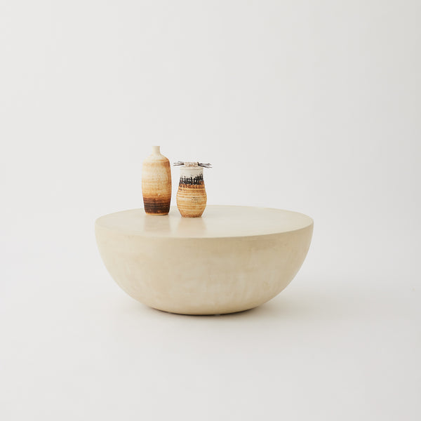 Moon round coffee table in Oyster micro-cement finish with smooth curved silhouette