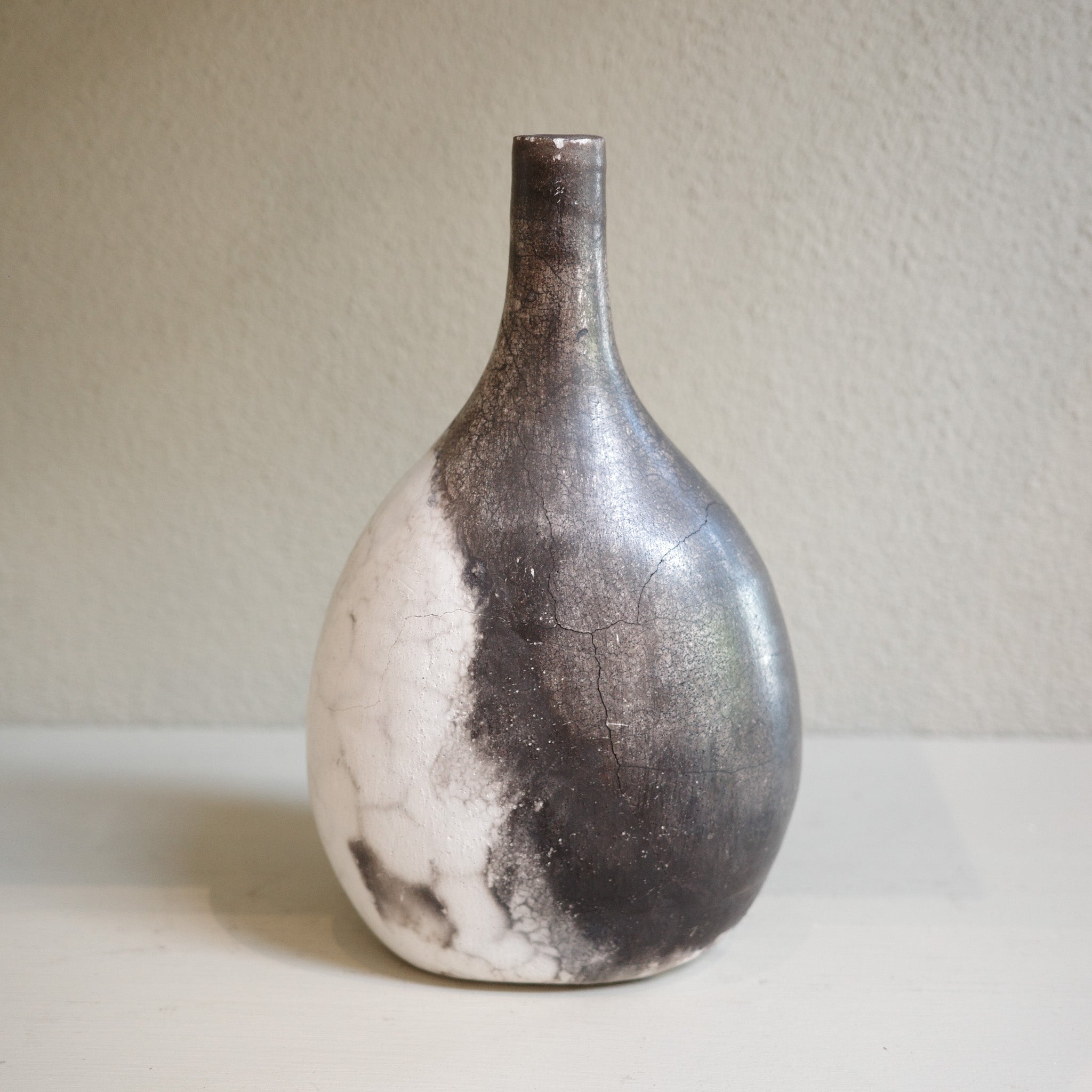 Unique ceramic bottle vase in Naked Raku firing technique, featuring organic smoke patterns.
