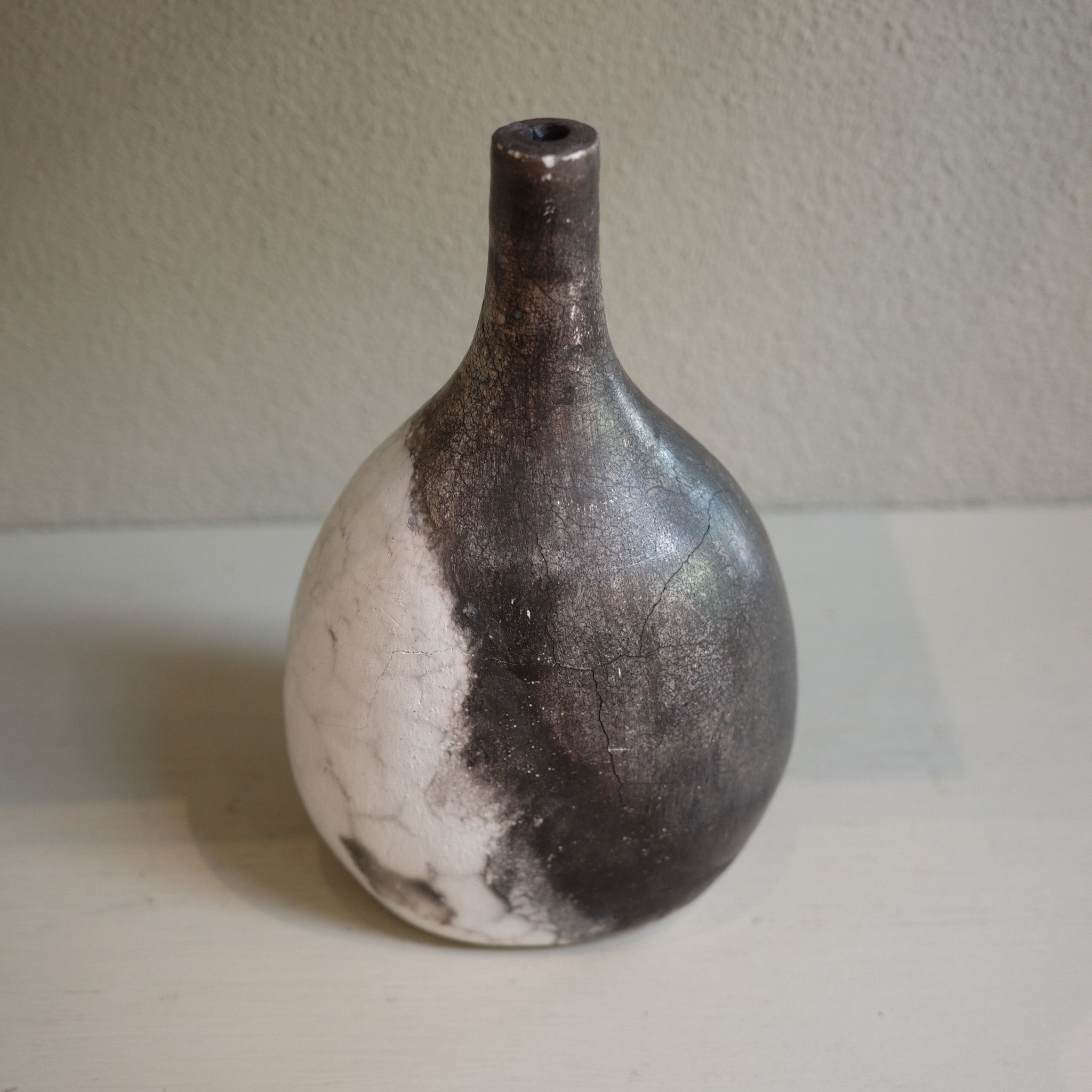 Unique ceramic bottle vase in Naked Raku firing technique, featuring organic smoke patterns.