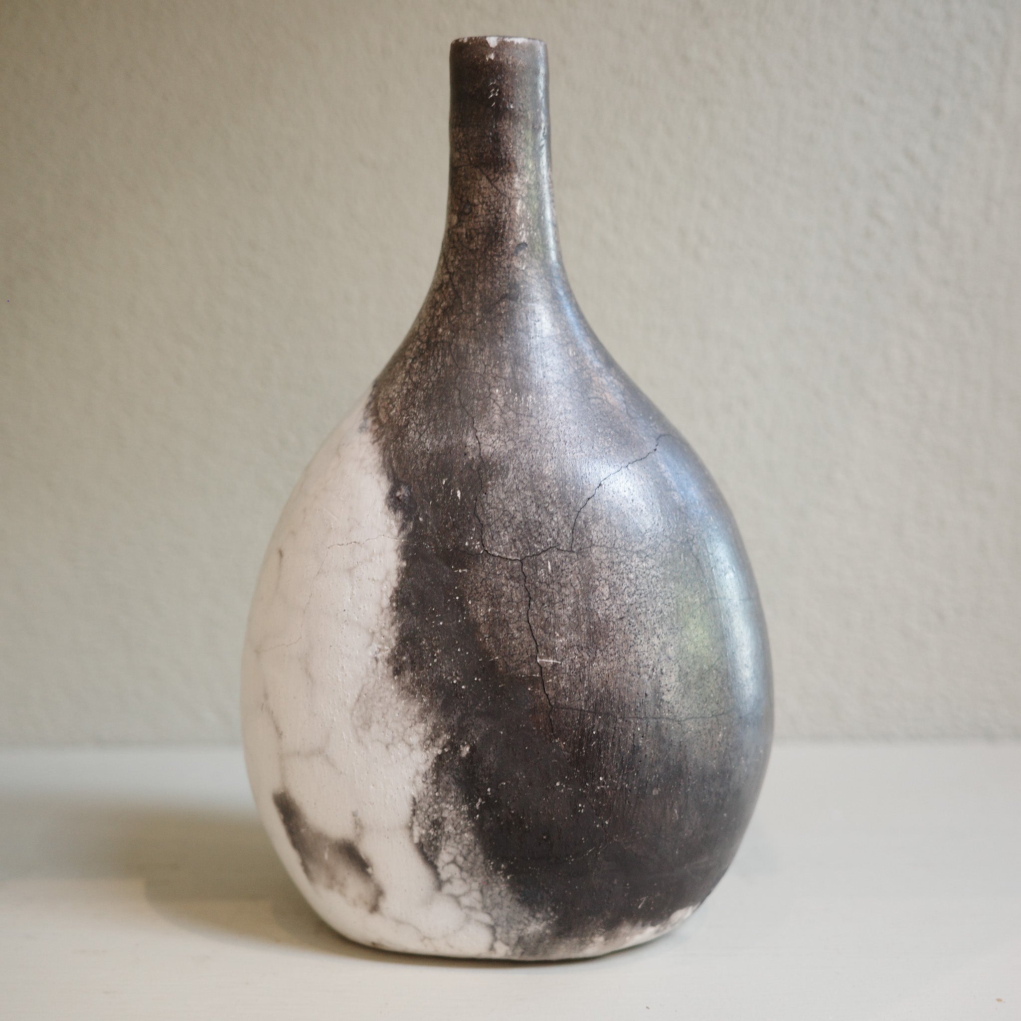 Unique ceramic bottle vase in Naked Raku firing technique, featuring organic smoke patterns.