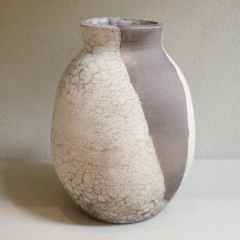 Close-up of naked raku vase showing organic black and white firing patterns