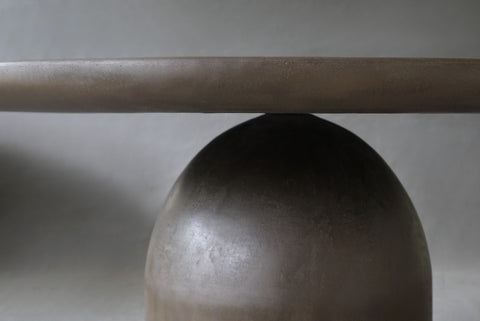 Closed-up of the Nexus Round Dining Table in Pebble highlighting smooth micro cement finish.