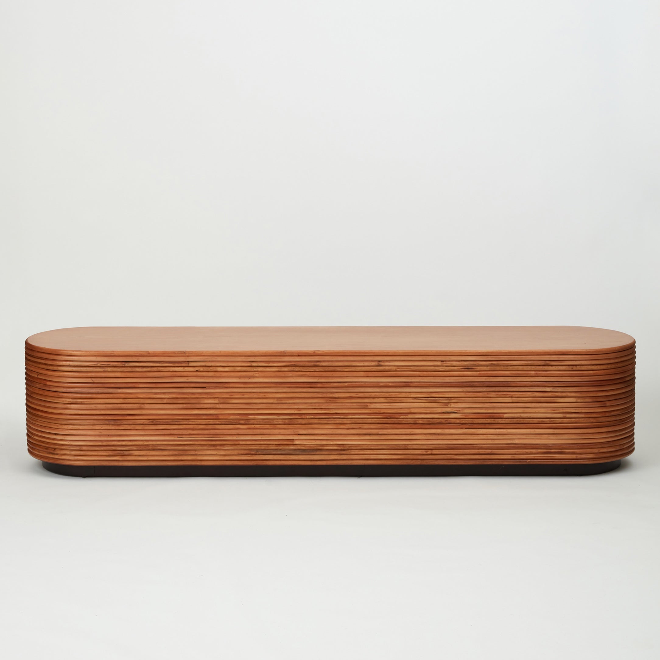Back view of the Panama rattan entertainment unit with stacked rattan cladding, golden oak shelving, and walnut-stained base