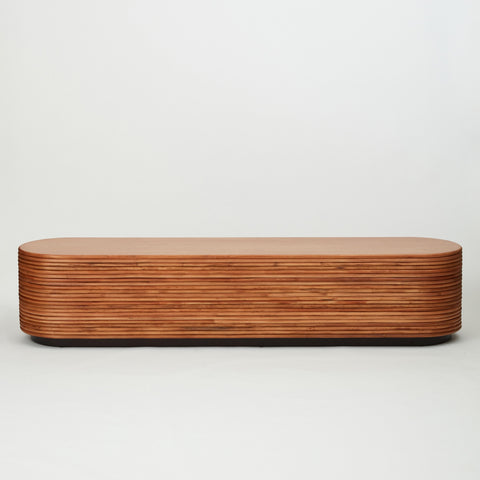 Back view of the Panama rattan entertainment unit with stacked rattan cladding, golden oak shelving, and walnut-stained base