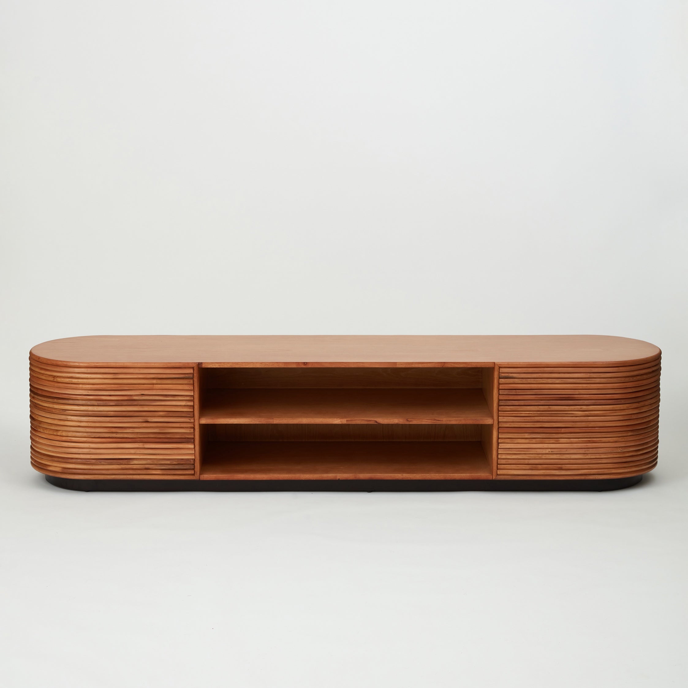 Panama rattan entertainment unit with stacked rattan cladding, golden oak shelving, and walnut-stained base