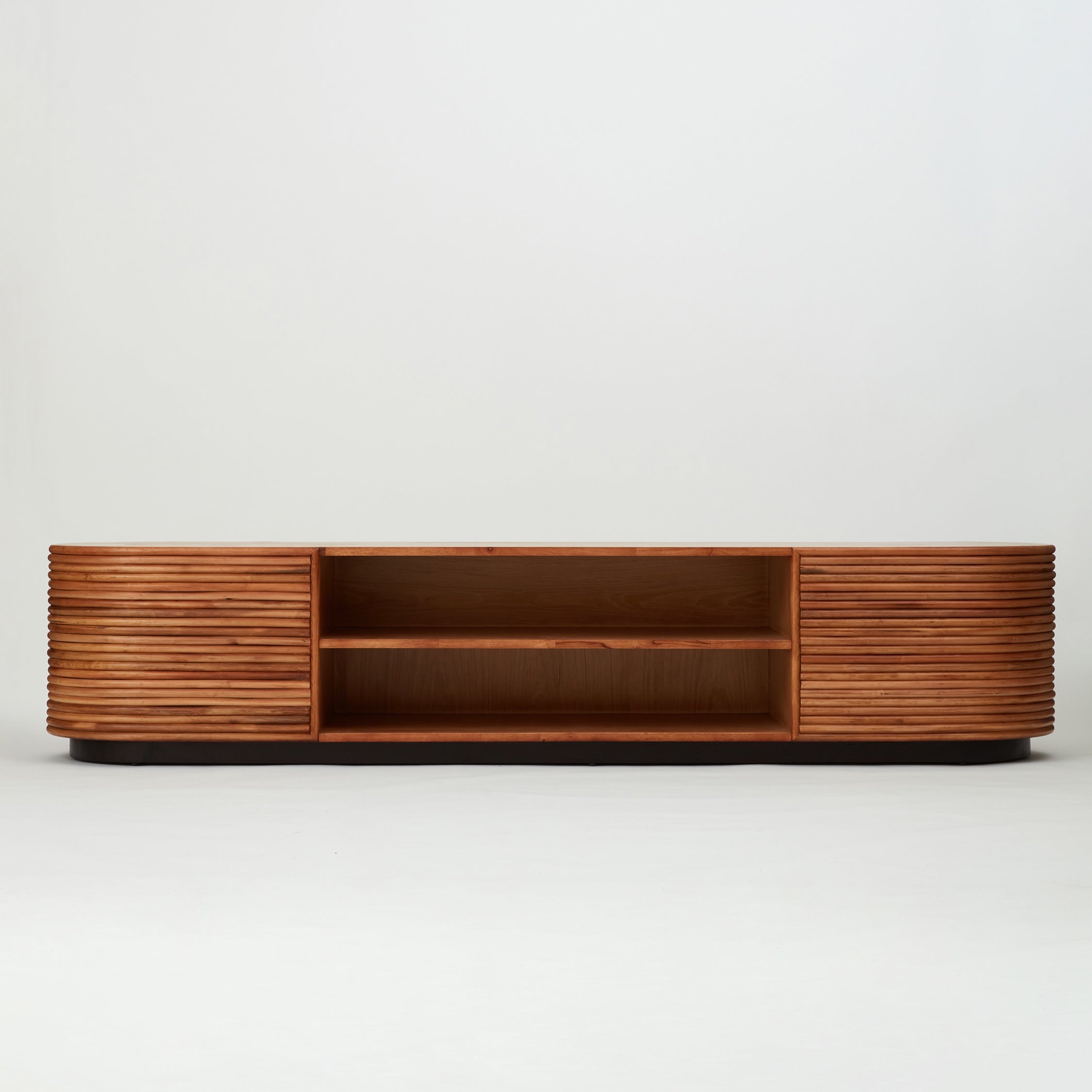 Front view of the Panama rattan entertainment unit with stacked rattan cladding, golden oak shelving, and walnut-stained base
