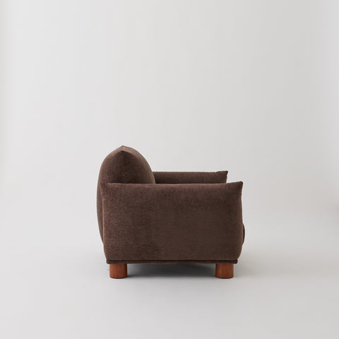 Side of the Sumi armchair in Mocha fabric
