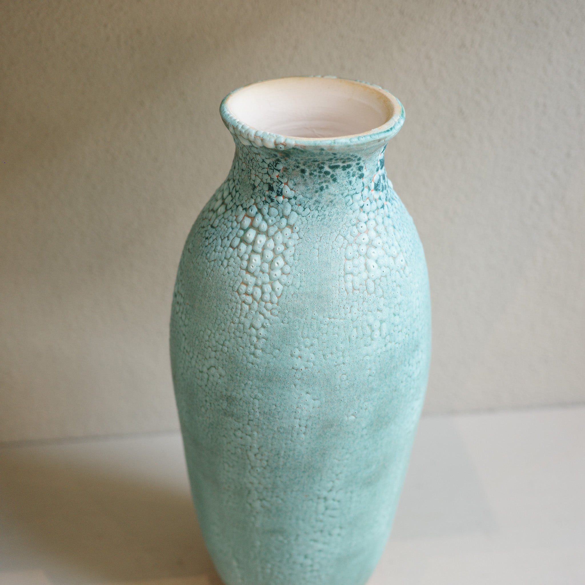 Handmade tall green ceramic vase with crawl glaze texture, created by Australian ceramicist Jacqui Sosnowski.