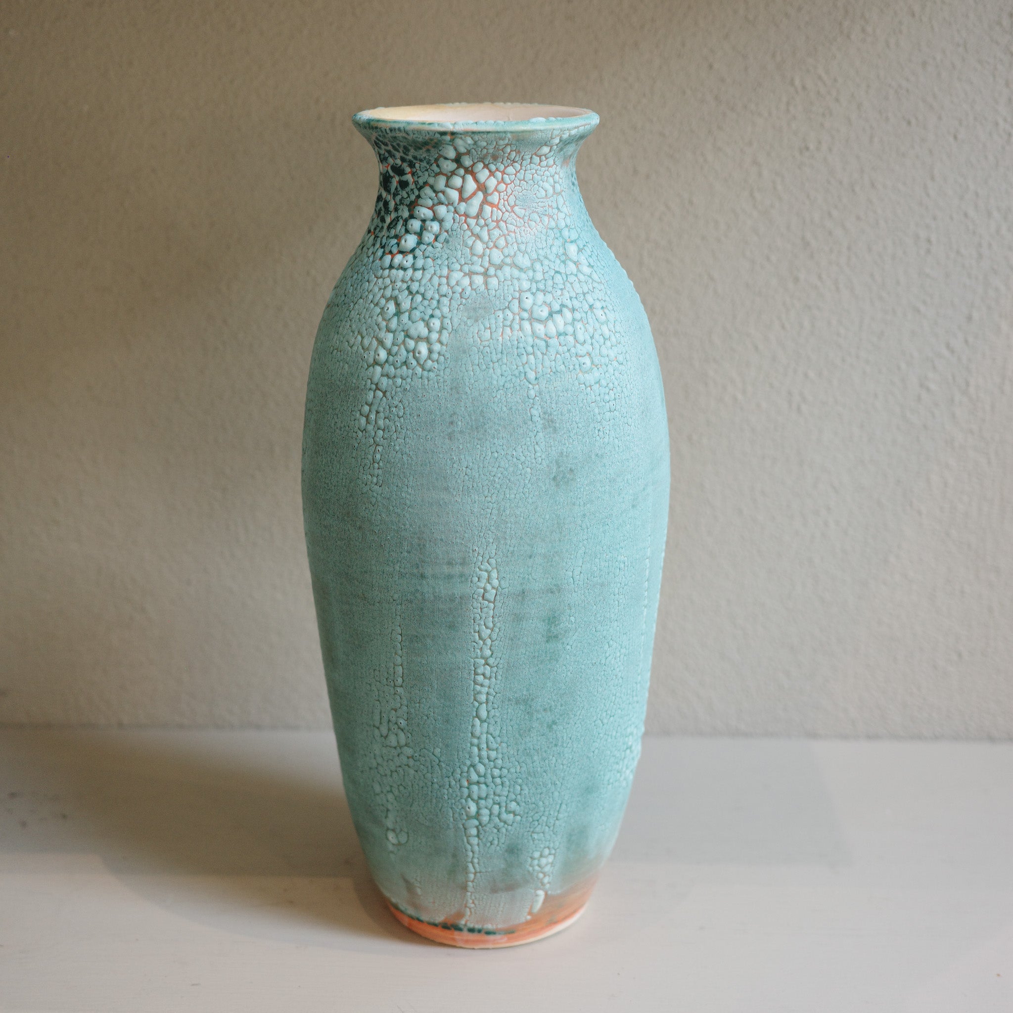Handmade tall green ceramic vase with crawl glaze texture, created by Australian ceramicist Jacqui Sosnowski.