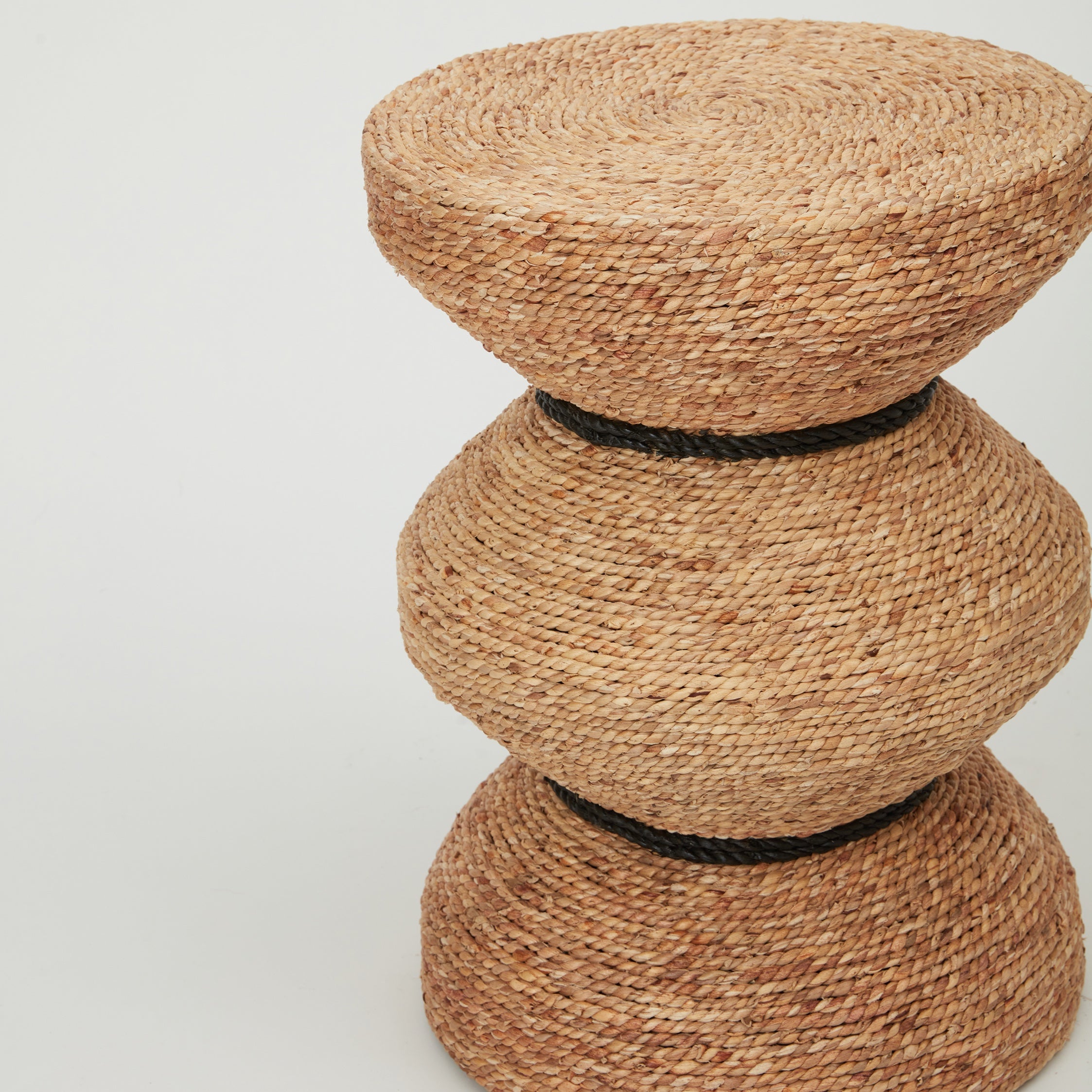 Close-up of Tiki side table showing handwoven banana leaf rope texture and sculptural design.